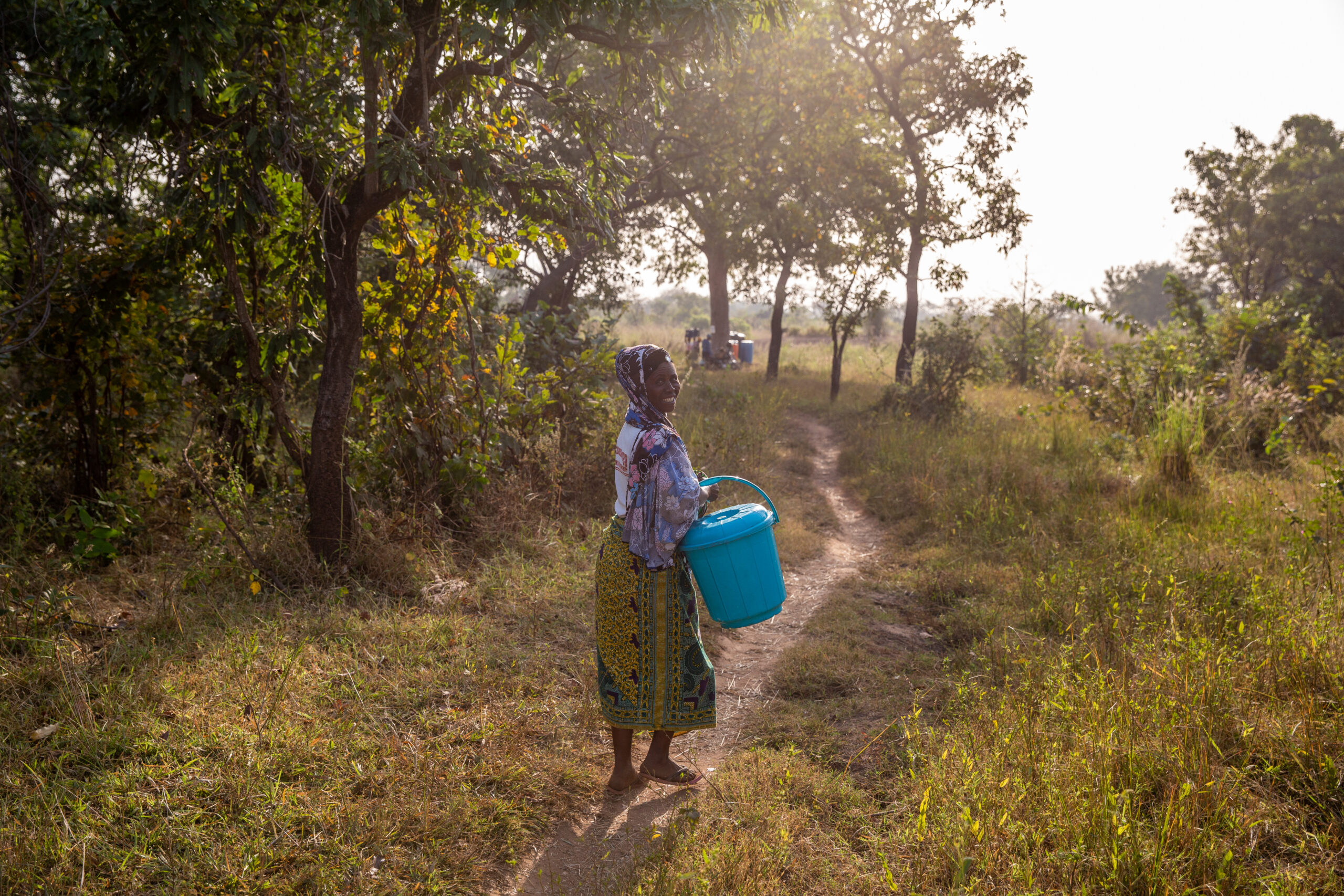 A woman walks with her safe storage container in Sakpaluwa on December 10, 2022.